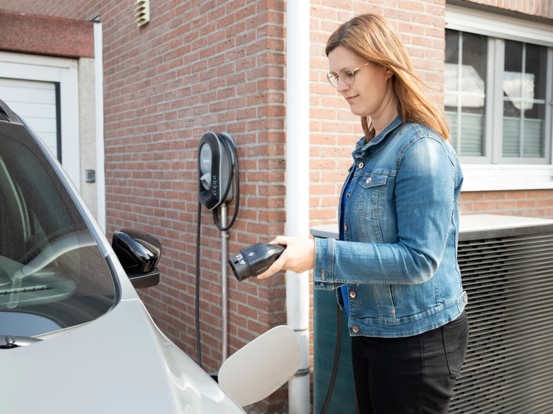 Frau schließt E-Auto an 