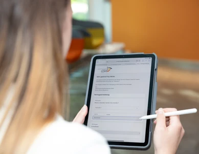 Frau füllt Formular auf Tablet aus