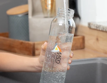 Eine Wasserflasche wird aufgefüllt.