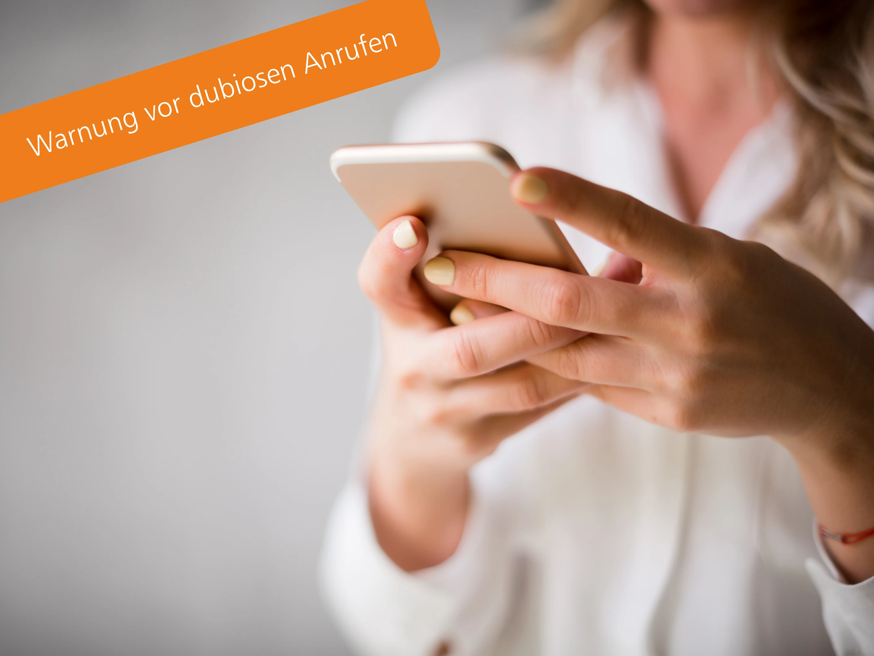Frau schaut auf ihr Smartphone. Die GSW warnen vor dubiosen Anrufen.