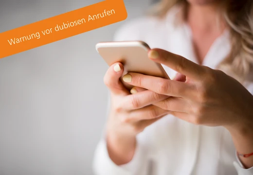 Frau schaut auf ihr Smartphone. Die GSW warnen vor dubiosen Anrufen.